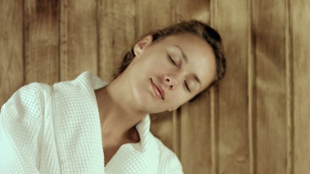 Relaxing woman stroking her skin in the sauna