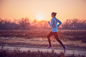 ragazza atletica si allena all'aperto su terra di sera