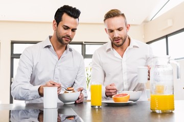 Unsmiling gay couple couple having breakfast 