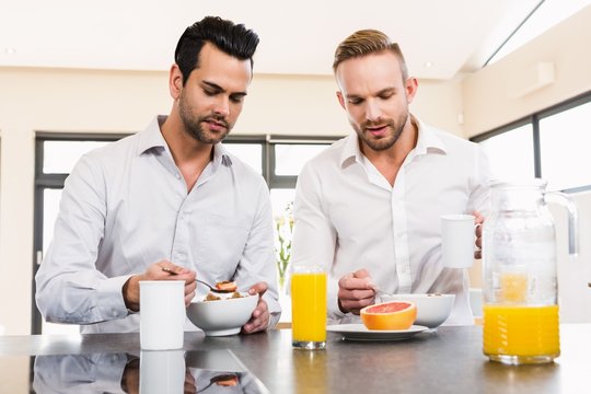 Unsmiling gay couple couple having breakfast 