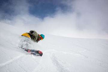 Man snowboarding on snow in the mountains