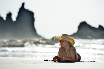 young woman sitting on the beach in summer vacation