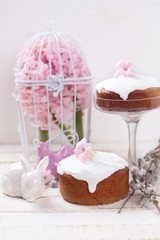Easter cake, rabbit, pink hyacinths, willow branches on white wooden background. Easter background. Selective focus.