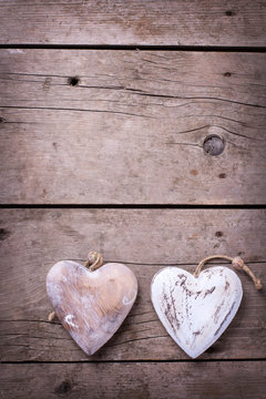 Two decorative  hearts on vintage wooden background.