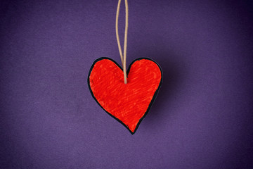 Obraz premium Red paper heart shape against purple background