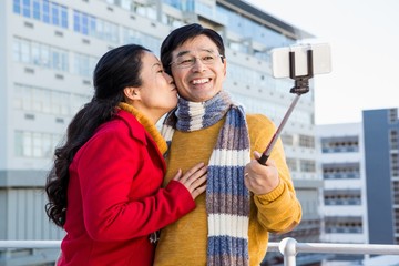 Older asian couple on balcony taking selfie