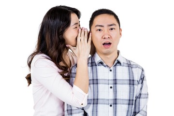 Woman whispering secret to husband 