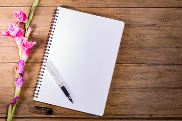 Blank Notebook with Flower on Wooden Table