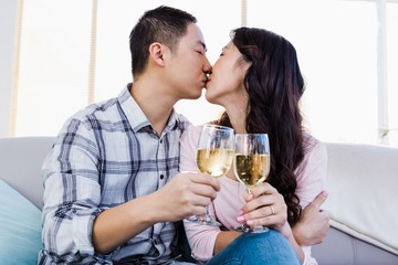 Young couple kissing and holding wineglasses