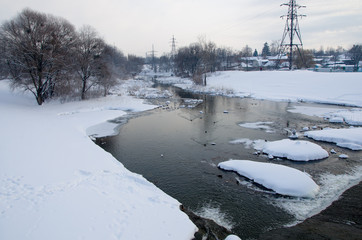 Winter landscape with frozen river , snow and sun