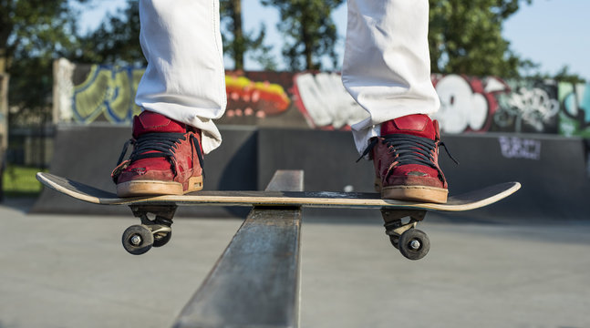 Skateboarder doing a skateboard sliding trick at skate park