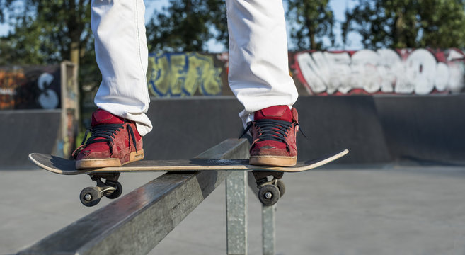 Skateboarder doing a skateboard sliding trick at skate park