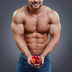 man bodybuilder holding a fresh fruits