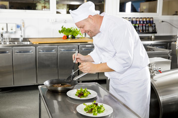 Smiling chef prepares steak dish at restaurant