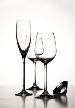 edle Weingläser und Sektglas mit Diamant auf weißem Hintergrund