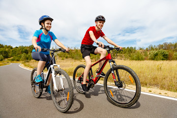 Fototapeta na wymiar Healthy lifestyle - teenage girl and boy cycling 