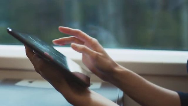 Using Tablet PC next to Window in Moving Train.  Shot on RED Cinema Camera.