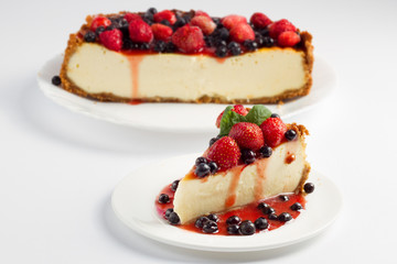 Cheesecake with blueberries and strawberry on white plate 