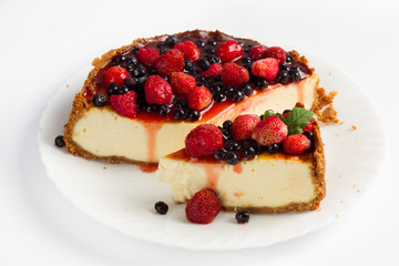 Cheesecake with blueberries and strawberry on white plate 
