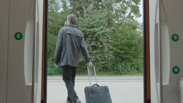  Businessman with Luggage Getting out the Train. Shot on RED Cinema Camera.