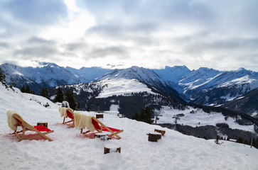 Red chairs against the backdrop of the mountains in the ski resort Zillertal, Austria.