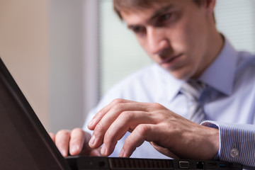 Young man enthusiastically working on the computer.