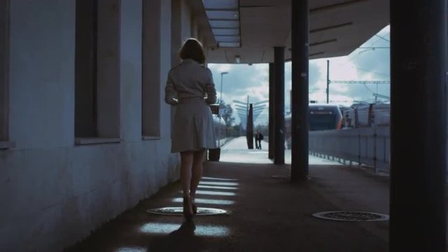 Confident Woman in Trench Walking in Railway Station. Shot on RED Cinema Camera.