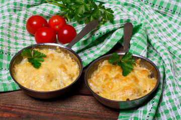 French cuisine. Сhicken with mushrooms baked with cheese in a cocotte