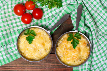 French cuisine. Сhicken with mushrooms baked with cheese in a cocotte