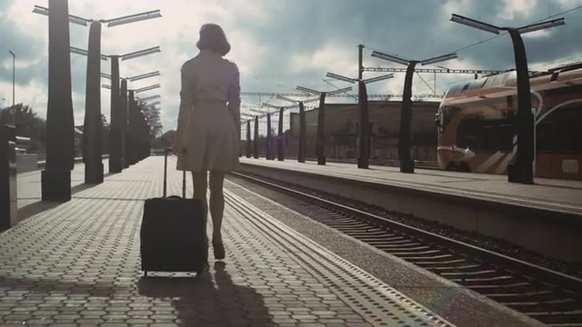 Following Shot of Confident Woman with Luggage Walking through Railway Station. Shot on RED Cinema Camera.