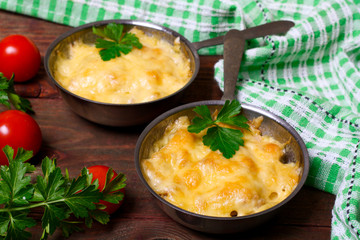 French cuisine. Сhicken with mushrooms baked with cheese in a cocotte