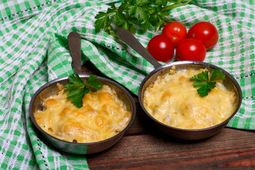 French cuisine. Сhicken with mushrooms baked with cheese in a cocotte