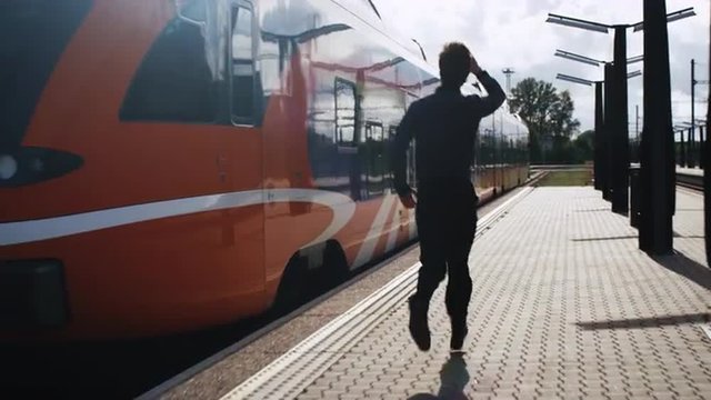 Man is Chasing Departing Train. Shot on RED Cinema Camera.