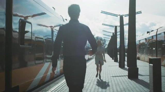 Man Meeting and Hugging Girlfriend at Arrival in Train Station. Shot on RED Cinema Camera.