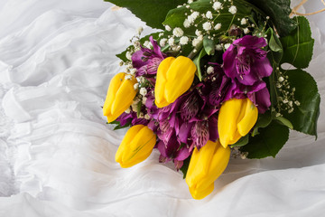 Spring flowers - yellow tulip and purple alstroemeria (lily of the Incas or Peruvian lily) with water drops - white background
