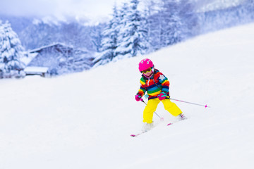 Fototapeta na wymiar Little girl skiing in the mountains