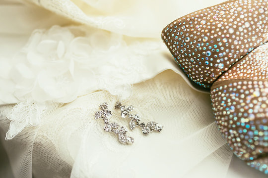 brides ear-rings on wedding dress background