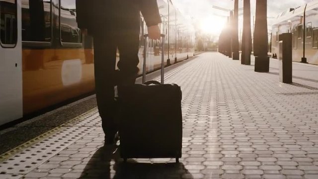  Confident Man With Luggage Walking on Railway Station at Sunset Time. Shot on RED Cinema Camera.