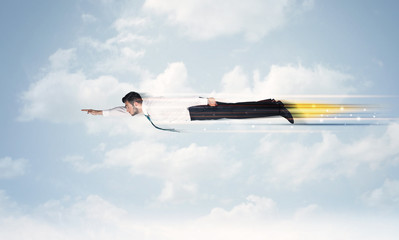 Happy business man flying fast on the sky between clouds