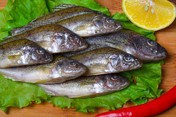raw redfish ruff fish on the kitchen table with vegetables and lemon