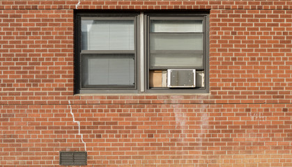 Window on brick red wall whith AC