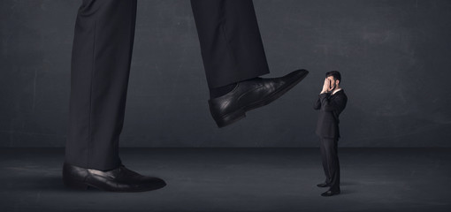 Giant person stepping on a little businessman concept