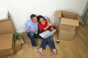 happy American couple sitting on floor kissing celebrating movin