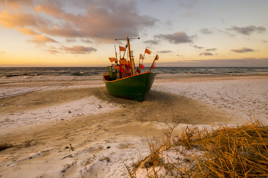 Fototapeta Kuter rybacki na bałtyckiej plaży zimą