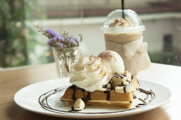 Waffles with banana, chocolate syrup and coffee