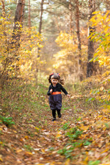 Girl running down the path in the autumn forest