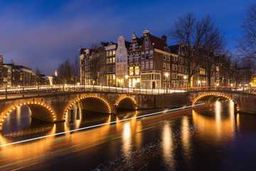 Fototapeta na wymiar Night view over Amsterdam canals and bridges, with lights and their trails