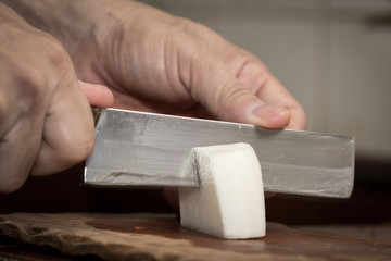 Chef peeling radish with Knife.