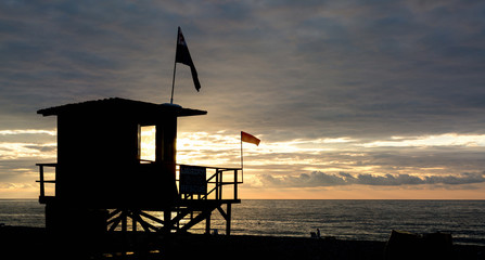 Lifeguard tower on the beach of Batumi at sunset on a background of sea and sky with clouds.