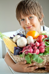 Happy little boy with fresh vegetables 